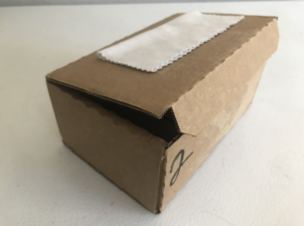 Photo of a shipping box, taken from an angle where it shows the top of the box and two sides